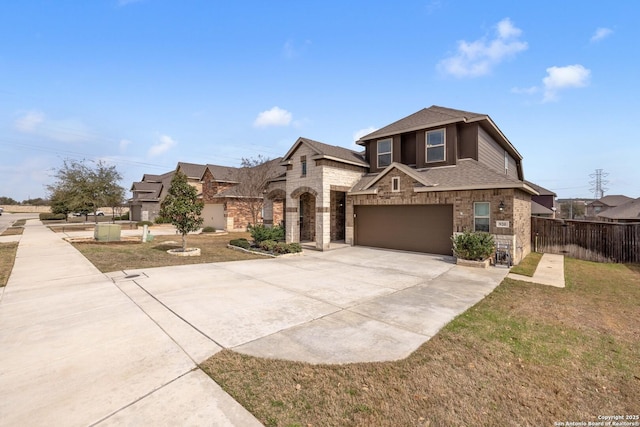 view of front of house featuring driveway, stone siding, fence, roof with shingles, and a garage