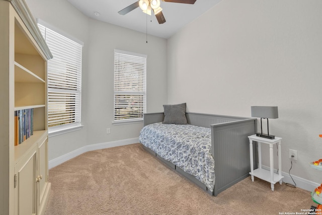 carpeted bedroom with ceiling fan and baseboards