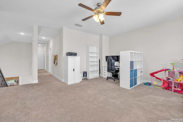 carpeted office space featuring visible vents, ceiling fan, and vaulted ceiling