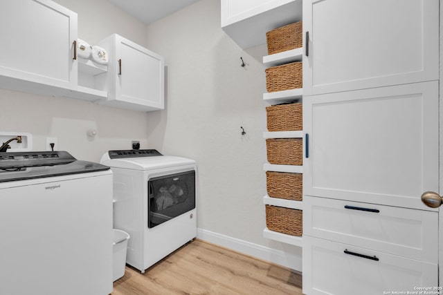 laundry area with baseboards, cabinet space, separate washer and dryer, and light wood finished floors