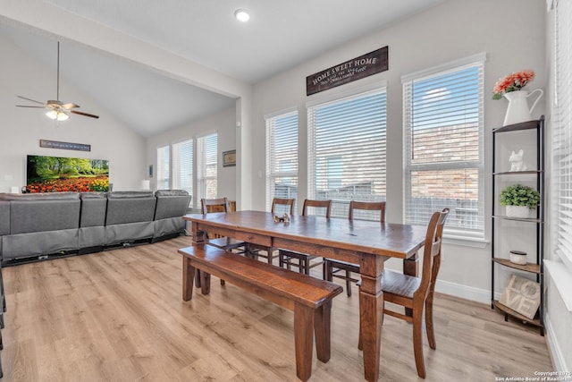 dining room featuring vaulted ceiling, light wood-style flooring, a ceiling fan, and baseboards