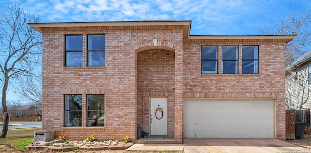 view of front of property with brick siding, an attached garage, and driveway