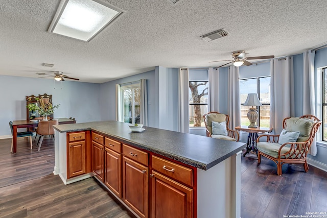 kitchen featuring dark countertops, open floor plan, and dark wood-style flooring