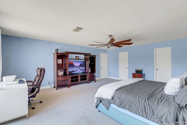 bedroom with visible vents, a ceiling fan, a textured ceiling, carpet flooring, and baseboards