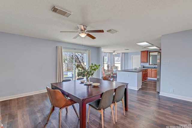 dining area with dark wood-style floors, visible vents, and baseboards