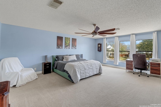 bedroom with visible vents, a textured ceiling, baseboards, and carpet floors