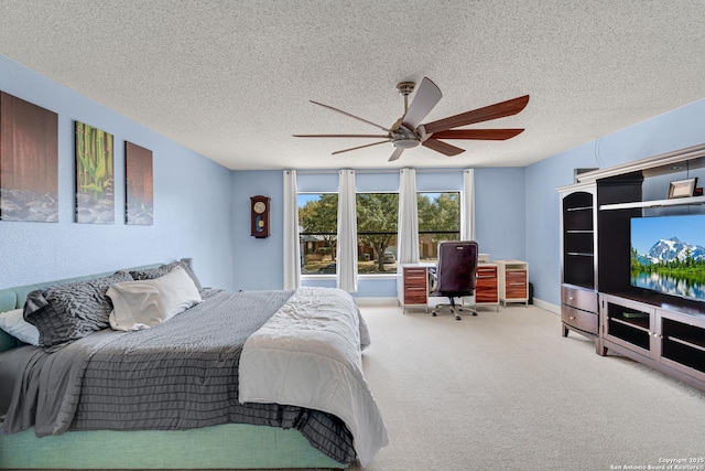 carpeted bedroom featuring ceiling fan, baseboards, and a textured ceiling