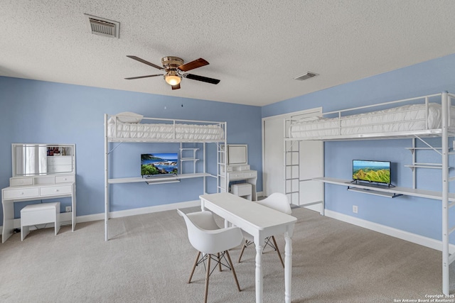 carpeted home office featuring visible vents, baseboards, and ceiling fan