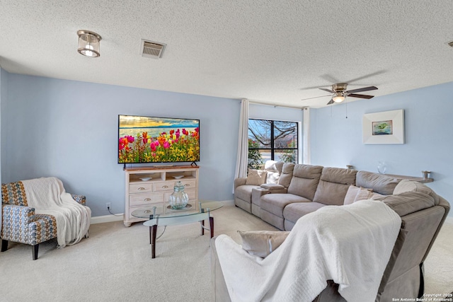 living room featuring a ceiling fan, carpet, visible vents, baseboards, and a textured ceiling