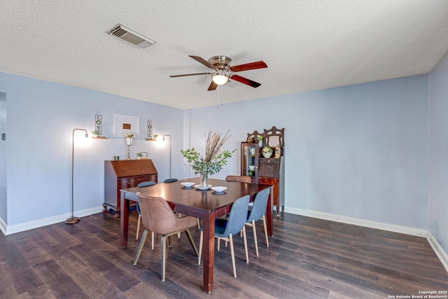 dining room featuring a ceiling fan, wood finished floors, visible vents, baseboards, and a textured ceiling