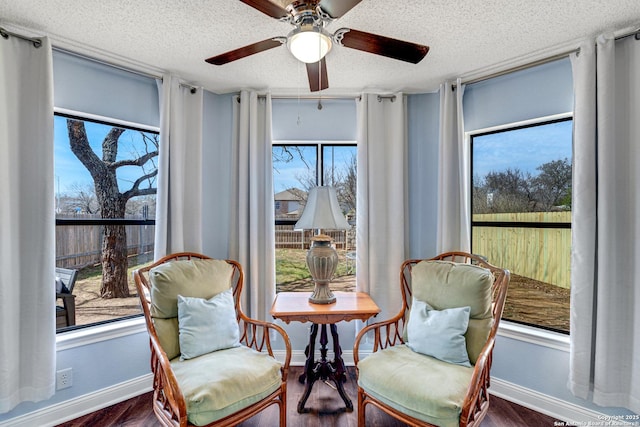 sitting room with floor to ceiling windows, wood finished floors, and a textured ceiling