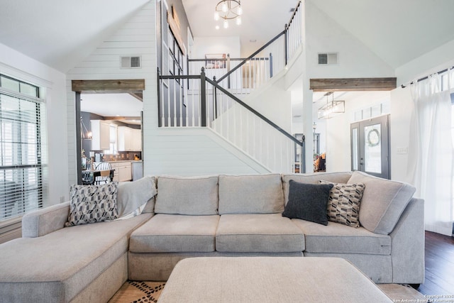 living area featuring visible vents, a healthy amount of sunlight, wood finished floors, and stairs