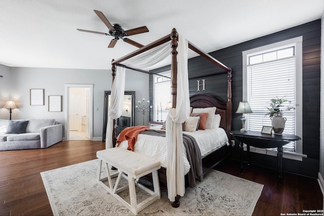 bedroom featuring wood finished floors, ensuite bathroom, and ceiling fan