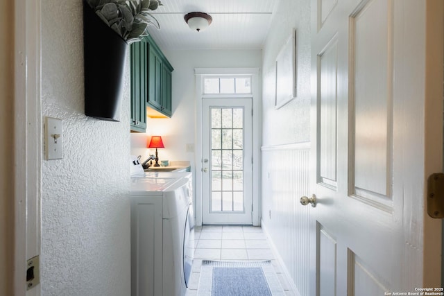 doorway to outside featuring light tile patterned floors, separate washer and dryer, and a textured wall