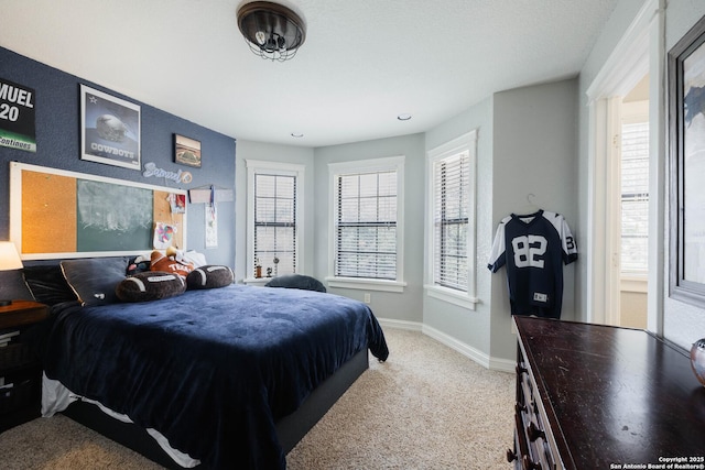 bedroom featuring baseboards and light carpet