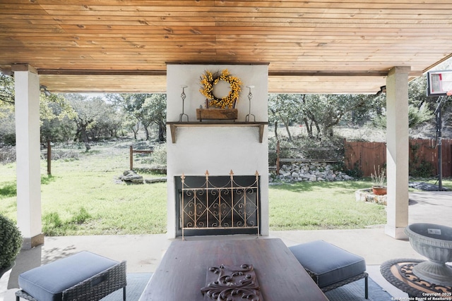 view of patio with fence and exterior fireplace