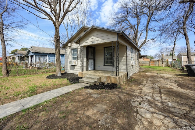 view of front of home featuring a porch, cooling unit, and fence