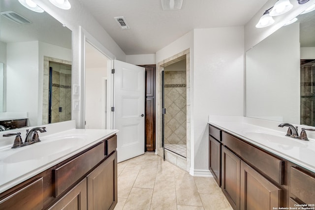 bathroom with a sink, visible vents, and a shower stall