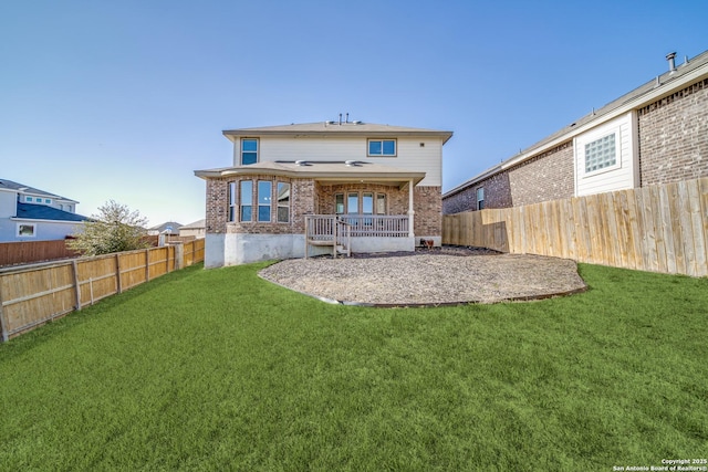 rear view of house with a yard, brick siding, and a fenced backyard