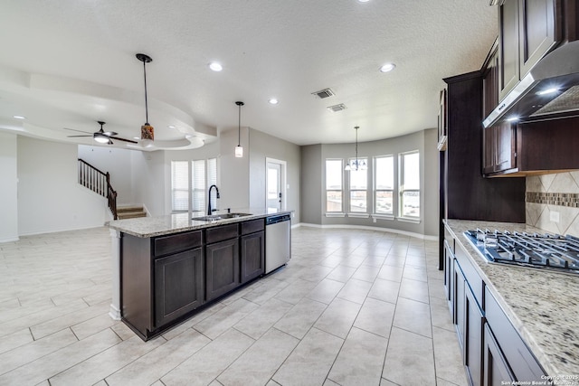 kitchen featuring under cabinet range hood, open floor plan, decorative backsplash, stainless steel appliances, and a sink