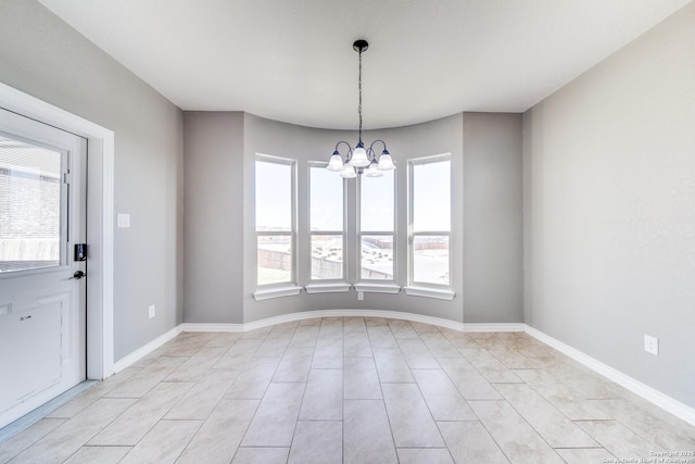 unfurnished room featuring baseboards and an inviting chandelier