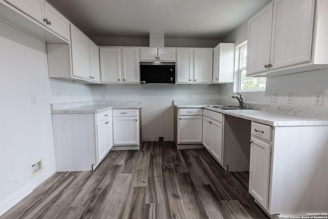 kitchen with white cabinetry, light countertops, dark wood-style flooring, and a sink