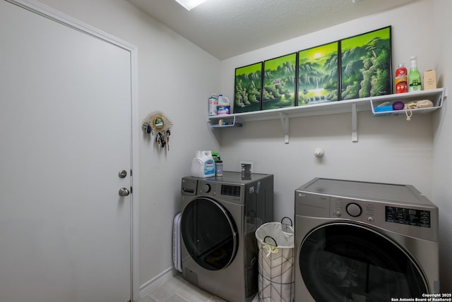 clothes washing area featuring light tile patterned floors, laundry area, and washer and clothes dryer