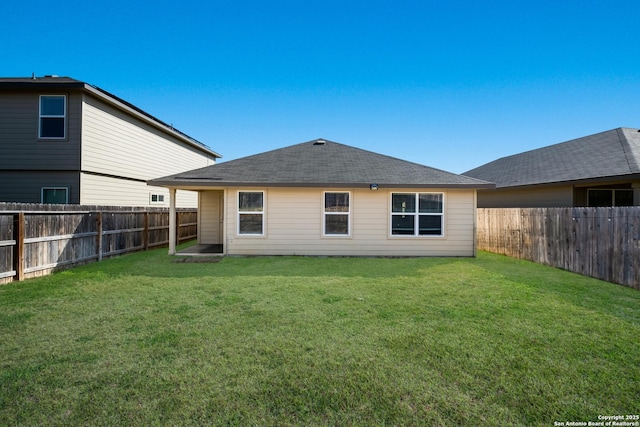 back of house featuring a lawn and a fenced backyard