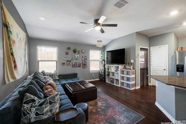 living room featuring a ceiling fan, dark wood-style floors, visible vents, baseboards, and lofted ceiling