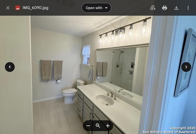 full bath featuring vanity, wood finished floors, a stall shower, a textured ceiling, and toilet