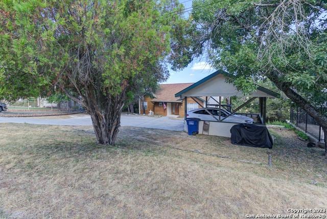 view of yard with a detached carport and concrete driveway