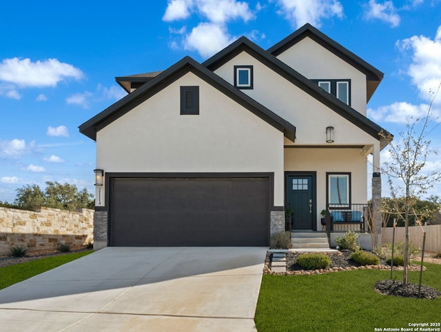 view of front facade with concrete driveway, an attached garage, and stucco siding