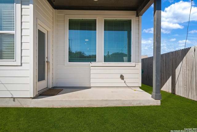 entrance to property with a lawn and fence