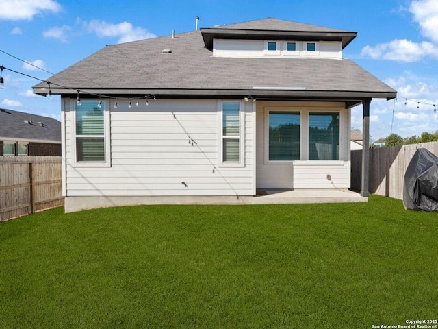 rear view of house with a yard, a patio, roof with shingles, and a fenced backyard