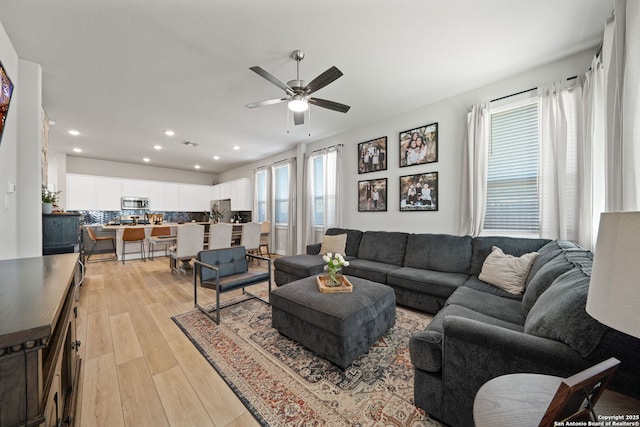 living area with light wood-style flooring, recessed lighting, and ceiling fan