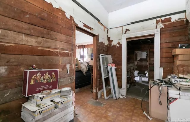 miscellaneous room featuring tile patterned floors and wood walls