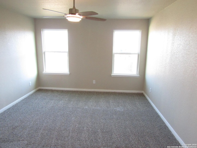 carpeted empty room featuring baseboards and ceiling fan