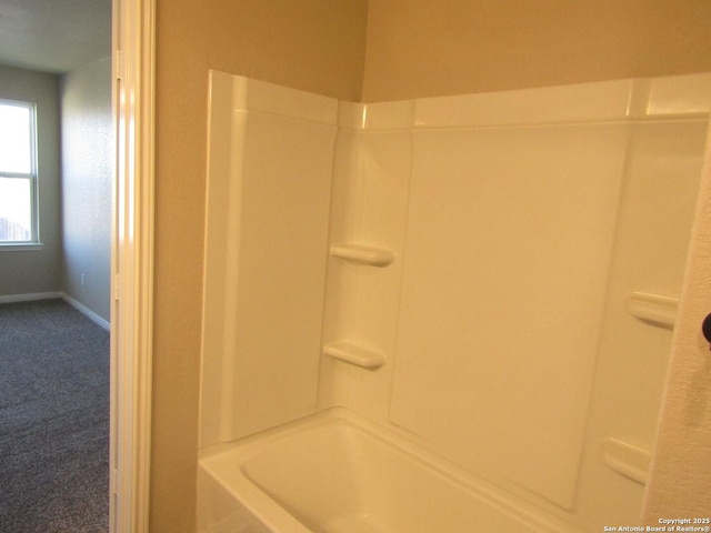 bathroom featuring shower / bathing tub combination and baseboards