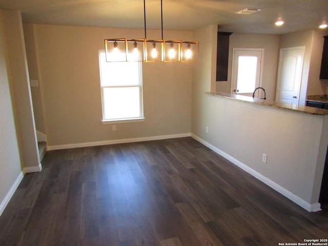 unfurnished dining area featuring dark wood-type flooring, recessed lighting, baseboards, and visible vents