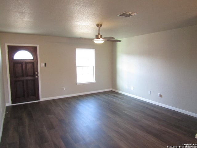 entrance foyer featuring dark wood-style floors, visible vents, ceiling fan, and baseboards