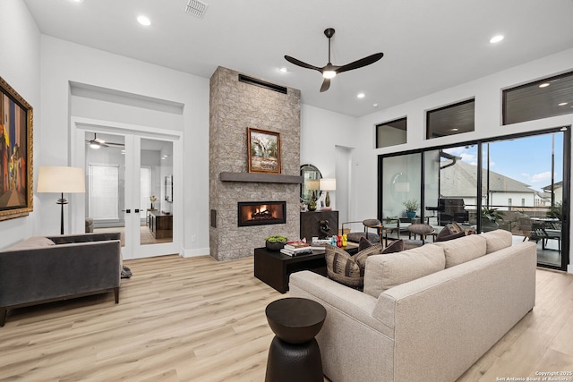 living area featuring a ceiling fan, visible vents, light wood finished floors, recessed lighting, and a fireplace