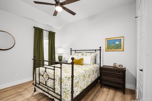 bedroom with ceiling fan, baseboards, lofted ceiling, and wood finished floors