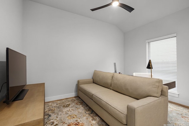 living area featuring vaulted ceiling, wood finished floors, a ceiling fan, and baseboards