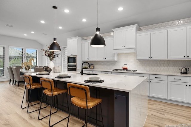 kitchen featuring a sink, stainless steel appliances, light wood-style floors, and white cabinetry