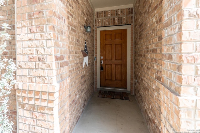 doorway to property featuring brick siding