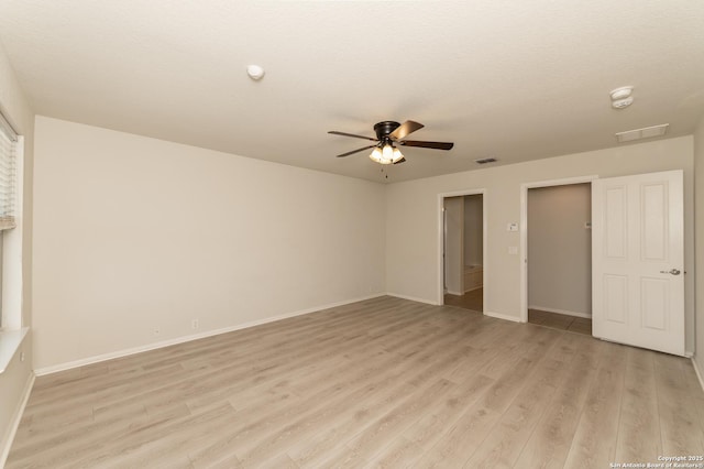 unfurnished bedroom featuring visible vents, baseboards, light wood-style floors, and a ceiling fan