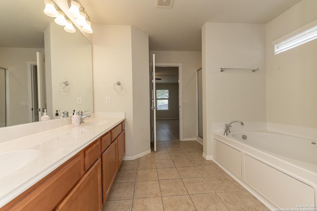 bathroom with tile patterned floors, a sink, a shower stall, double vanity, and a bath