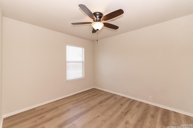 empty room featuring light wood finished floors, a ceiling fan, and baseboards