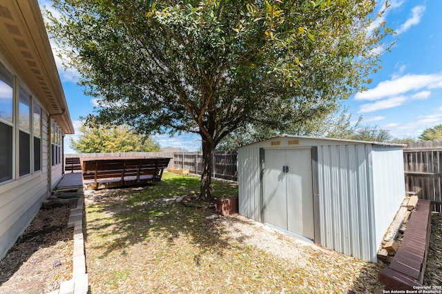 view of yard featuring an outdoor structure, a fenced backyard, and a shed