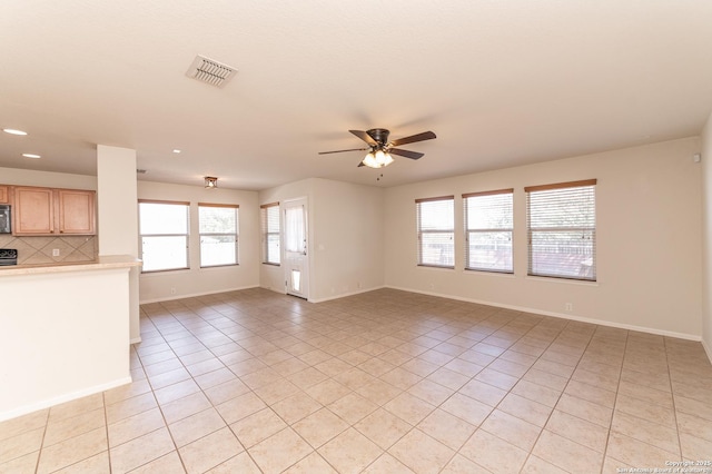 unfurnished living room featuring ceiling fan, visible vents, baseboards, and light tile patterned flooring